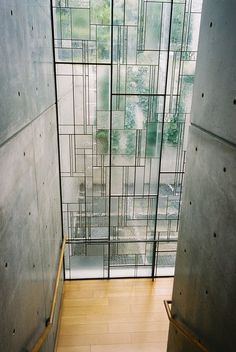 an open glass door leading to a room with wooden floors and walls that have been made from stained glass