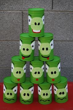 stacks of green paper cups with faces painted on them