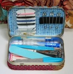 an open tin with toothbrushes, scissors and other items in it