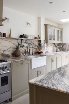 a kitchen with marble counter tops and white cabinets