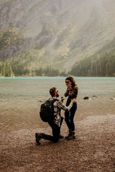 two people standing on the shore of a lake