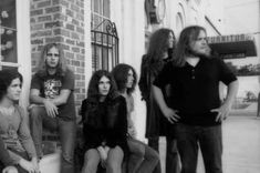 a group of young people sitting on the side of a building