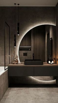 a bathroom with a sink, mirror and bathtub in the center is lit by lights