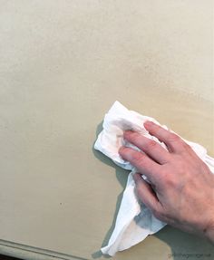 a person wiping up some paper with a cloth