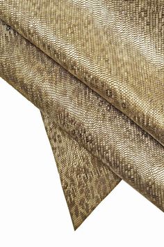 a close up view of the fabric on a tablecloth with gold and brown patterns