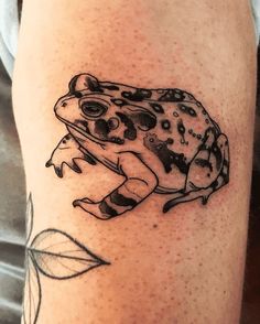 a black and white frog tattoo on the leg