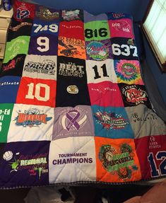 a bed covered in lots of t - shirts on it's sides and numbers