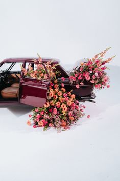 an old car with flowers growing out of it