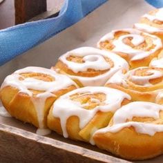 several cinnamon rolls with icing sitting in a pan