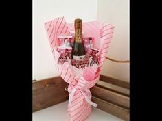 a wine bottle wrapped in pink paper and tied to a rope