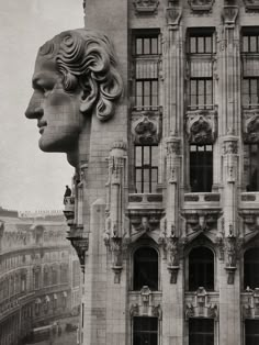 an old photo of a building with a giant head on it's face and windows