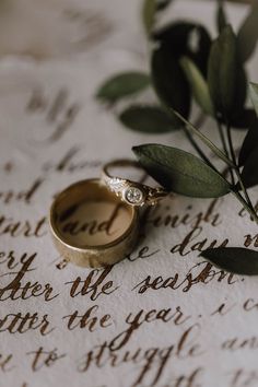 two wedding rings sitting on top of an old letter