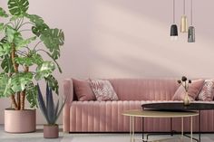 a living room with pink couches and potted plants on the side table in front of it