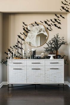 a white dresser topped with lots of drawers and birds flying over the top of it