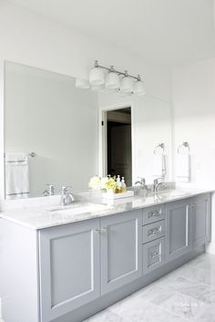 a large bathroom with two sinks and mirrors