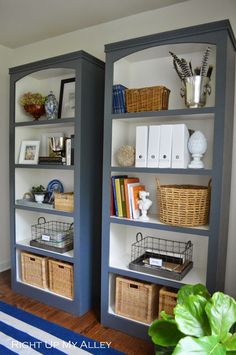 two gray bookcases with baskets and books on them