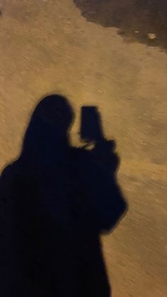 the shadow of a person holding a cell phone