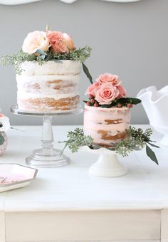 there are three cakes on the table and one is decorated with pink flowers in it