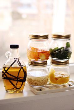 three jars filled with different types of food sitting on a window sill next to each other