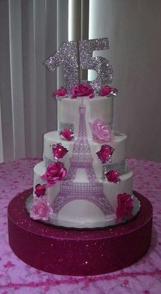 a white cake with pink flowers and the eiffel tower