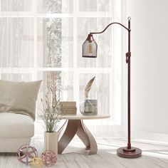 a living room scene with focus on the floor lamp and table in front of the window