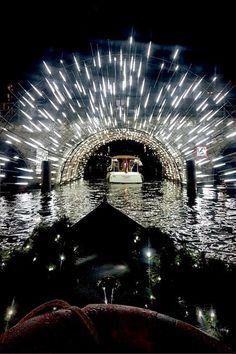 a boat traveling through a tunnel filled with lights