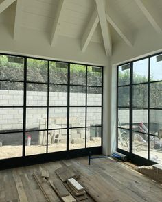 an empty room with wooden floors and large windows that have glass panes on them