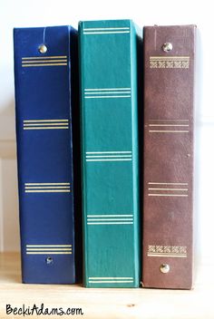 three books sitting on top of each other in front of a white wall and wooden floor