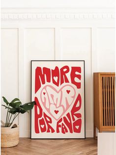 a red and white poster with the words more than love on it next to a potted plant