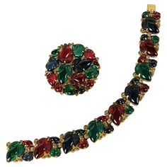 Rare Trifari Art Deco Fruit Salad Suite, KTF by Alfred Phillipe circa 1930's. A matching set with brooch and bracelet covered in faux ruby, emerald and sapphire fruits set in gilt metal with tiny pave accents. 1930's USA. Brooch 1 5/8", Bracelet 7" x 5/8". KTF signature. Deco Fruit, Trifari Jewelry, Ruby Emerald, Fruit Art, Macedonia, Fruit Salad, Link Bracelets, Vintage Jewelry, Emerald