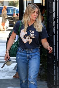 a woman walking down the street in ripped jeans