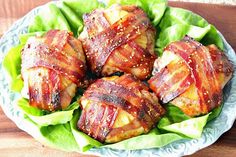 bacon wrapped chicken in lettuce on a blue and white plate with wooden table