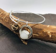 This lovely handcrafted beach bangle from Scotland is made with a lovely smooth white beach pebble found in Kintyre on the West coast.  The pebble  charm is set in a Fine Silver bezel sitting on a sterling silver backing.  The delicate 0.95mm thick silver bangle is adjustable  and will expand to fit most wrists.    Other similar items available: Pendants: https://www.etsy.com/uk/shop/RockLobsterCrafts?ref=l2-shopheader-name&section_id=24274610 Bangles & bracelets:  https://www.etsy.com/uk/shop/R Adjustable Silver Bracelet With Round Pendant, Minimalist White Bangle Gift, Minimalist White Bangle For Gift, White Minimalist Bangle, White Bangle For Gift, Handmade White Bangle As Gift, Pebble Jewelry, Scottish Jewellery, Bangle Silver