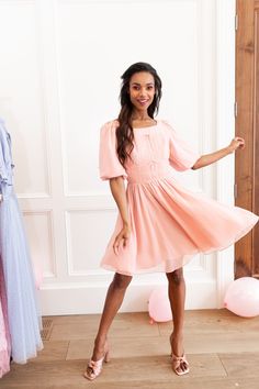 This soft pink knee-length dream dress has it all! From the bows, to the ruching and light-weight fabric, this feminine number is sure to become one of your favorite things. Inspired by Liesl Von Trapp in the Sound of Music. Available in size XXS-5X + matching mini sizes! Spring Feminine Mini Dress With Ruched Bodice, Feminine Spring Mini Dress With Ruched Bodice, Pink Ruched Knee-length Mini Dress, Pink Puff Sleeve Dress With Ruched Bodice, Feminine Mini Dress With Smocked Bodice, Feminine Knee-length Dress With Pleated Waist, Knee-length Dress With Gathered Waist For Brunch, Feminine Pink Midi Dress With Pleated Bodice, Pink Ruched Short Sleeve Midi Dress