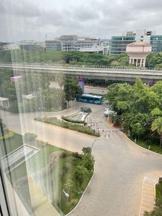 an aerial view of a city street from a high rise window with trees and buildings in the background