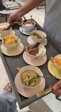 a table topped with bowls and plates filled with soup next to another bowl full of food