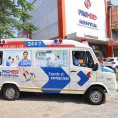 an ambulance is parked in front of a hospital with medical staff on it's side