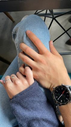 a person with their hand on the leg of another persons arm and wearing a watch