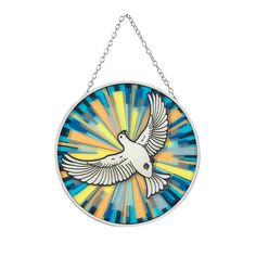 a stained glass bird hanging from a chain on a white wall with blue, yellow and orange colors