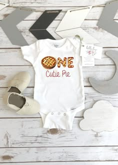 a onesie with the word one cutie pie on it and some other items