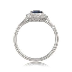 This stunning sapphire ring centers a 1.48 carat sapphire bezel set in handcrafted platinum. Surrounding the center gem is a halo of lively diamonds. This ring is further adorned by a stunning openwork filigree under-gallery and fine milgrain. ✦ DIAMOND SPECIFICATIONS: Diamond Cut: Emerald Cut Diamond Weight 1.48 Carats ✦ ENGAGEMENT RING SPECIFICATIONS: Ring Material: Platinum Stones: Diamond, Sapphire ✦ WHAT COMES IN YOUR SHIPMENT: - Your Engagement Ring - Quality Ring Box - Jewelry Cleaner - U Gia Certified Cushion Cut Sapphire Ring In Platinum, Classic Gia Certified Sapphire Ring, Classic Gia Certified Sapphire Platinum Ring, Classic Gia Certified Platinum Sapphire Ring, Gia Certified Platinum Sapphire Ring, Round Cut, Classic Gia Certified Emerald Cut Sapphire Ring, Timeless Gia Certified Platinum Sapphire Ring, Fine Jewelry Platinum Cushion Cut Sapphire Ring, Classic Platinum Sapphire Ring With Center Stone