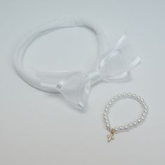 Cherish this important day with the perfect baby baptism gift: a Marcela's Satin Bow & Pearl Bracelet Set with Jeweled Cross handmade with love. Comes in a 2" white satin bow with a jeweled cross and a 2mm off-white pearl bracelet,  this timeless piece is sure to be a favorite.  SKU: SET-BOW-BRCT-1 Baby Baptism Gifts, Chiffon Bow, Jersey Headband, Personalized Bible, White Pearl Bracelet, Baby Baptism, Baby Bloomers, Wedding Jewelry Bracelets, Baptism Gifts