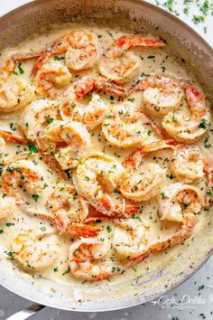 a skillet filled with shrimp and grits on top of a white countertop