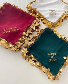 three gold and green sequins are on top of a white cloth with the words denja & sari written on it