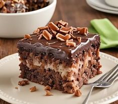 a piece of cake on a plate with a fork next to it and another dish in the background