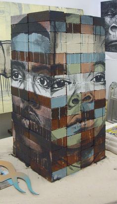 a sculpture made out of several different colored blocks with faces painted on the top and bottom