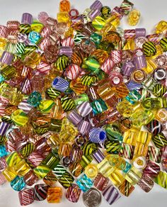 many different colored glass beads on a white surface