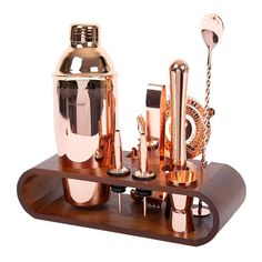 a set of copper colored bar accessories on a wooden stand