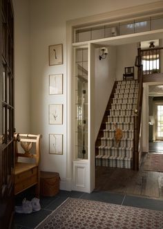 an open door leading to a staircase in a house with pictures on the wall and carpeted floor