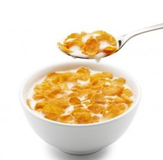 a white bowl filled with cereal on top of a spoon next to an orange slice